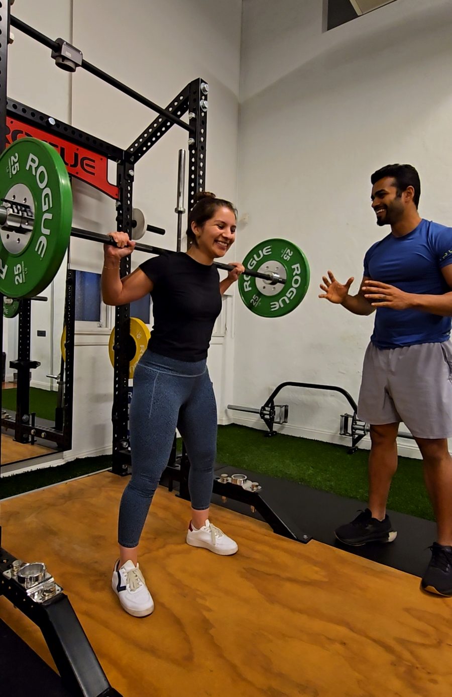 Moideen coaching a client through a barbell squat at MyoLab in Oakland